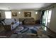 Comfortable living room featuring a plush sectional, hardwood floors, and ample natural light at 18436 W Shasta St, Goodyear, AZ 85338