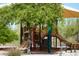 View of the community playground featuring play structures, a covered picnic area, and landscaping in the Estrella community at 18436 W Shasta St, Goodyear, AZ 85338