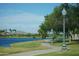View of a walking path with decorative lights and a lake in the Estrella community at 18436 W Shasta St, Goodyear, AZ 85338