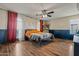 This bedroom boasts wood floors, a ceiling fan, wainscoting and natural light at 21033 N Alexis Ave, Maricopa, AZ 85138
