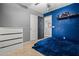 Stylish bedroom featuring a comfortable bed, dresser, blue accent wall, and carpeted floors at 21033 N Alexis Ave, Maricopa, AZ 85138