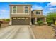 This two-story home features desert landscaping, a two-car garage, and a charming front porch at 21033 N Alexis Ave, Maricopa, AZ 85138