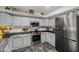 Well-lit kitchen with stainless steel appliances, overhead decor shelf and light grey cabinets at 21033 N Alexis Ave, Maricopa, AZ 85138