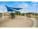 Community playground featuring a covered area with a picnic table, playground equipment and shade canopies at 21033 N Alexis Ave, Maricopa, AZ 85138