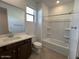 Bright bathroom featuring a modern vanity, large mirror, and a shower-tub combination for a clean and functional design at 25146 W Wayland Dr, Buckeye, AZ 85326
