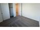 Neutral bedroom with carpeted floor, closet, and ample natural light, creating a cozy, inviting space at 25146 W Wayland Dr, Buckeye, AZ 85326