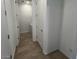 Hallway featuring a laundry area with white walls and tile flooring at 25146 W Wayland Dr, Buckeye, AZ 85326