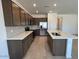 Modern kitchen with stainless steel appliances, center island, quartz countertops, and ample cabinet space at 25146 W Wayland Dr, Buckeye, AZ 85326