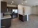 Modern kitchen with stainless steel appliances, center island, quartz countertops, and ample cabinet space at 25146 W Wayland Dr, Buckeye, AZ 85326