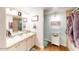 Bathroom with dual sinks, granite countertops, wood-style floor and decorative cabinet for extra storage at 3002 N 70Th St # 120, Scottsdale, AZ 85251
