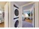 A stacked washer and dryer laundry unit in a hallway closet next to a bedroom at 3002 N 70Th St # 120, Scottsdale, AZ 85251
