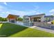 Backyard view of a modern home with a pool, waterfall feature, outdoor kitchen, and manicured landscaping at 3981 E Runaway Bay Pl, Queen Creek, AZ 85142