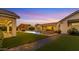 A scenic backyard featuring a custom pool, outdoor kitchen and modern fire pit at 3981 E Runaway Bay Pl, Queen Creek, AZ 85142