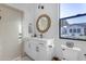 Modern bathroom with white cabinets, a round mirror with natural wood trim and a window view at 3981 E Runaway Bay Pl, Queen Creek, AZ 85142