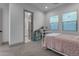 Bright bedroom featuring neutral walls, carpeted floor, and comfortable single bed with doorway leading to bathroom at 3981 E Runaway Bay Pl, Queen Creek, AZ 85142