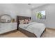 A cozy bedroom with an upholstered bed, dresser, mirror and plenty of natural light from the window at 3981 E Runaway Bay Pl, Queen Creek, AZ 85142