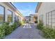 Beautiful courtyard featuring brick pavers, white exterior walls, manicured hedges and water feature at 3981 E Runaway Bay Pl, Queen Creek, AZ 85142