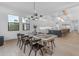 Dining room boasts a wooden table, modern chandelier, and view into the gourmet kitchen with island seating at 3981 E Runaway Bay Pl, Queen Creek, AZ 85142