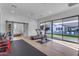 Bright workout room with wood floor, mirrors, gym equipment, and views of the pool at 3981 E Runaway Bay Pl, Queen Creek, AZ 85142