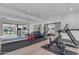 Bright workout room with wood floor, mirrors, gym equipment, and views of the pool at 3981 E Runaway Bay Pl, Queen Creek, AZ 85142