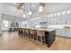 Modern kitchen with large island and seating, white cabinets, pendant lights and open to a dining area at 3981 E Runaway Bay Pl, Queen Creek, AZ 85142