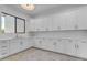 Bright laundry room featuring sleek white cabinets, modern countertops, and a stainless-steel sink with stylish wood floor at 3981 E Runaway Bay Pl, Queen Creek, AZ 85142