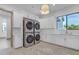 Bright laundry room with stacked washer/dryer, white cabinetry, ample counter space, sink, and herringbone floor at 3981 E Runaway Bay Pl, Queen Creek, AZ 85142