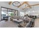 Open-concept living room features a large sectional sofa, statement lighting, and a view of the outdoor living space at 3981 E Runaway Bay Pl, Queen Creek, AZ 85142