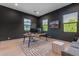 This office features dark walls, a modern desk, a gray ottoman, and natural light from the windows at 3981 E Runaway Bay Pl, Queen Creek, AZ 85142