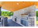 Close-up of an outdoor kitchen with a built-in grill, cabinetry, and countertop space at 3981 E Runaway Bay Pl, Queen Creek, AZ 85142