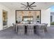 Covered outdoor patio with large sliding doors, dining table, ceiling fan, and living room views at 3981 E Runaway Bay Pl, Queen Creek, AZ 85142