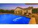 Tranquil twilight shot of a modern pool with in-water lounge chairs and lush landscaping at 3981 E Runaway Bay Pl, Queen Creek, AZ 85142