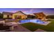 Backyard oasis with sparkling pool, built-in hot tub, lush lawn, and covered outdoor kitchen at 3981 E Runaway Bay Pl, Queen Creek, AZ 85142