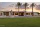 Expansive modern home with lush green lawn, desert landscaping, and soaring palm trees at dusk at 6633 E Horseshoe Rd, Paradise Valley, AZ 85253