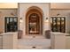 Elegant arched entryway with stone accents, flanked by stylish windows and planters, creating a welcoming entrance at 6633 E Horseshoe Rd, Paradise Valley, AZ 85253