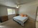Cozy carpeted bedroom featuring a ceiling fan, neutral walls, and a bright window overlooking the backyard at 12836 N 39Th Ln, Phoenix, AZ 85029