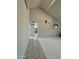 Hallway with ceramic tile floor leading into a room with vaulted ceilings and a bathroom at 12836 N 39Th Ln, Phoenix, AZ 85029