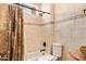 Cozy bathroom features tan tiled walls, a tub, and a toilet, creating a clean, functional space at 21483 N 65Th Ave, Glendale, AZ 85308
