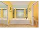 Bright bathroom has a large soaking tub, neutral tile, and ample natural light from the expansive window at 21483 N 65Th Ave, Glendale, AZ 85308