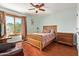 Comfortable bedroom features a ceiling fan, natural light, and wood-style floors at 21483 N 65Th Ave, Glendale, AZ 85308