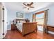 Comfortable bedroom features a ceiling fan, natural light, and wood-style floors at 21483 N 65Th Ave, Glendale, AZ 85308