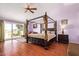 Spacious bedroom boasts a four-poster bed, wood floors, and access to a private balcony with scenic views at 21483 N 65Th Ave, Glendale, AZ 85308