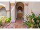 Inviting front entryway with a tiled landing, arched doorway and desert landscaping at 21483 N 65Th Ave, Glendale, AZ 85308