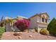 Beautiful two-story home featuring desert landscaping with vibrant pink floral bushes at 21483 N 65Th Ave, Glendale, AZ 85308