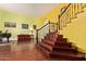 Grand foyer showcasing wood floors, a staircase with iron railing, and bright yellow walls at 21483 N 65Th Ave, Glendale, AZ 85308