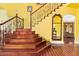 Foyer features wooden floors, staircase with iron railing, and a decorative mirror at 21483 N 65Th Ave, Glendale, AZ 85308