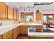 Bright kitchen features light wood cabinets, stainless appliances, views to the outside, and an island cooktop at 21483 N 65Th Ave, Glendale, AZ 85308