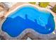 Aerial view of a private backyard pool with unique shape and surrounding patio at 21483 N 65Th Ave, Glendale, AZ 85308