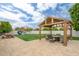 Charming backyard with a covered pergola, outdoor seating, and a play structure, perfect for Gathering fun and relaxation at 2431 E Laurel St, Mesa, AZ 85213