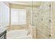 Bright bathroom featuring a glass enclosed shower, bathtub, and plantation shutters at 2431 E Laurel St, Mesa, AZ 85213